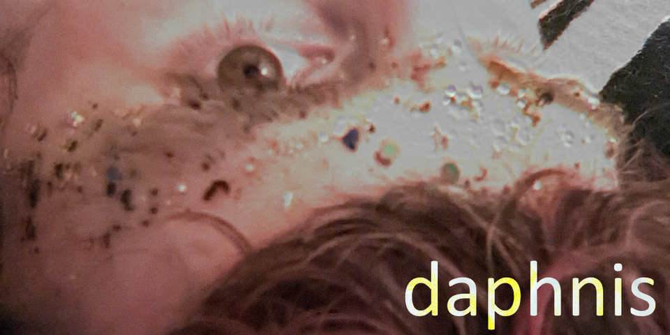 upside down pic of daphnis' brow, eye, hair, covered in glitter, the name "daphnis"